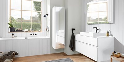 Ein modernes Badezimmer mit einer weißen Badewanne, einem eleganten Waschbecken und einem großen Fenster, das Tageslicht hereinlässt.