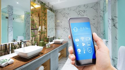 Ein modernes Badezimmer mit eleganten Waschbecken und einem Smartphone, das eine smarte Steuerung zeigt.
