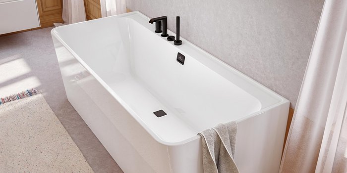 In einem stilvollen Badezimmer befindet sich eine schlichte Badewanne mit schwarzen Armaturen und einem minimalistischen Design.